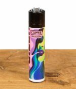 Ein einzelnes Clipper Feuerzeug aus der "Gizeh Faces Vol. 1" Serie mit einem farbenfrohen Gesichterdesign auf einer Holzoberfläche.
