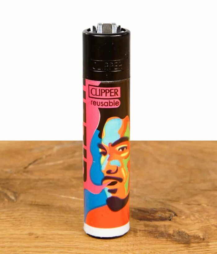 Ein einzelnes Clipper Feuerzeug aus der "Gizeh Faces Vol. 1" Serie mit einem farbenfrohen Gesichterdesign auf einer Holzoberfläche.