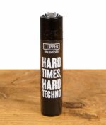 Clipper Feuerzeug mit "Hard Times, Hard Techno" Design, schwarzes Gehäuse mit weißem Schriftzug.