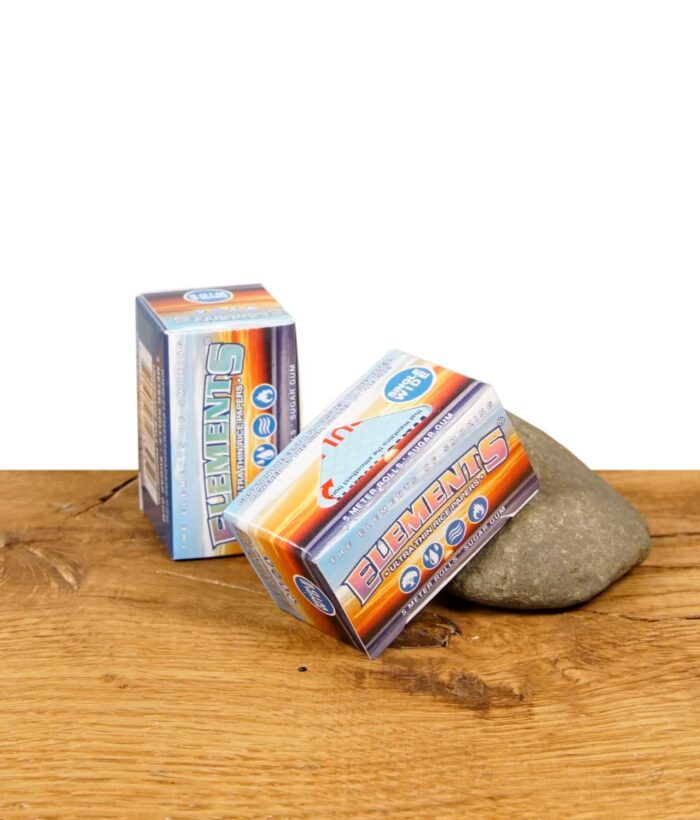 Zwei Schachteln Elements Ultra Thin Rolls auf einem Stein, eine leicht geöffnet.
