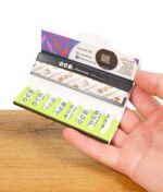 Geöffnete Packung OCB Slim Premium Papers mit Activ’Tips Slim Filtern in der Hand gehalten. Alles griffbereit für den perfekten Rauchgenuss.