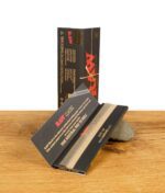 Eine geöffnete Packung RAW Black King Size Papers mit einem Blättchen und dem Slogan "The Natural Way to Roll".