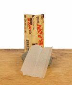 Ein offenes RAW Classic Rolling Paper im Single Wide Format mit Cut Corners, auf einem Stein präsentiert