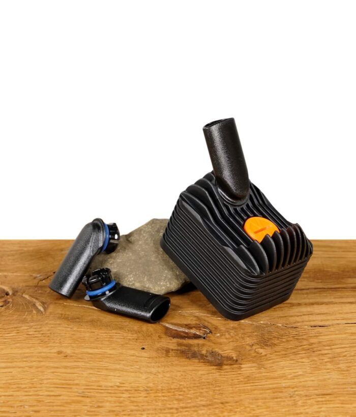 Venty Kühlungseinheit und Mundstücke neben einem Stein auf einem Holztisch.