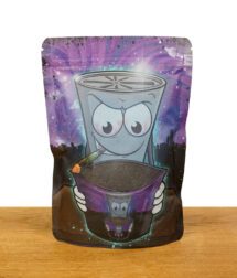 Vorderseite einer Verpackung veganer Kokosaktivkohle mit kreativem Cartoon-Design, das eine rauchende Cartoonfigur darstellt, die eine Tüte Aktivkohle hält, vor einem galaktischen Hintergrund.