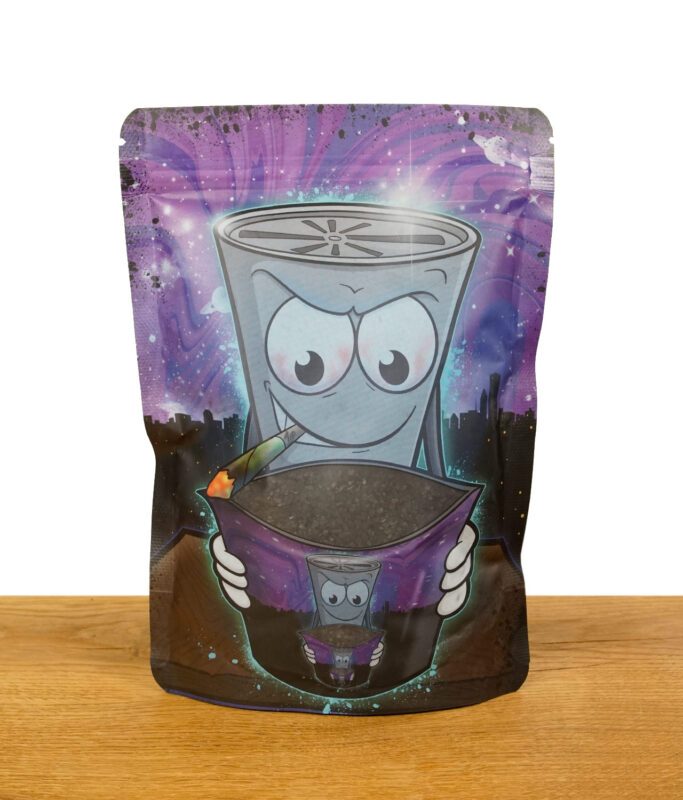Vorderseite einer Verpackung veganer Kokosaktivkohle mit kreativem Cartoon-Design, das eine rauchende Cartoonfigur darstellt, die eine Tüte Aktivkohle hält, vor einem galaktischen Hintergrund.