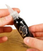 2 Hände die eine Squeezeflasche von 1Tip halten