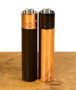 Zwei Clipper-Feuerzeuge, eines in Schwarz mit kupferner Kappe und das andere in Kupfer mit schwarzer Kappe, nebeneinander aufgestellt