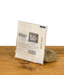 Integra Boost 55% Feuchtigkeitsregler auf Holzoberfläche, verpackt und angelehnt an einen Stein.