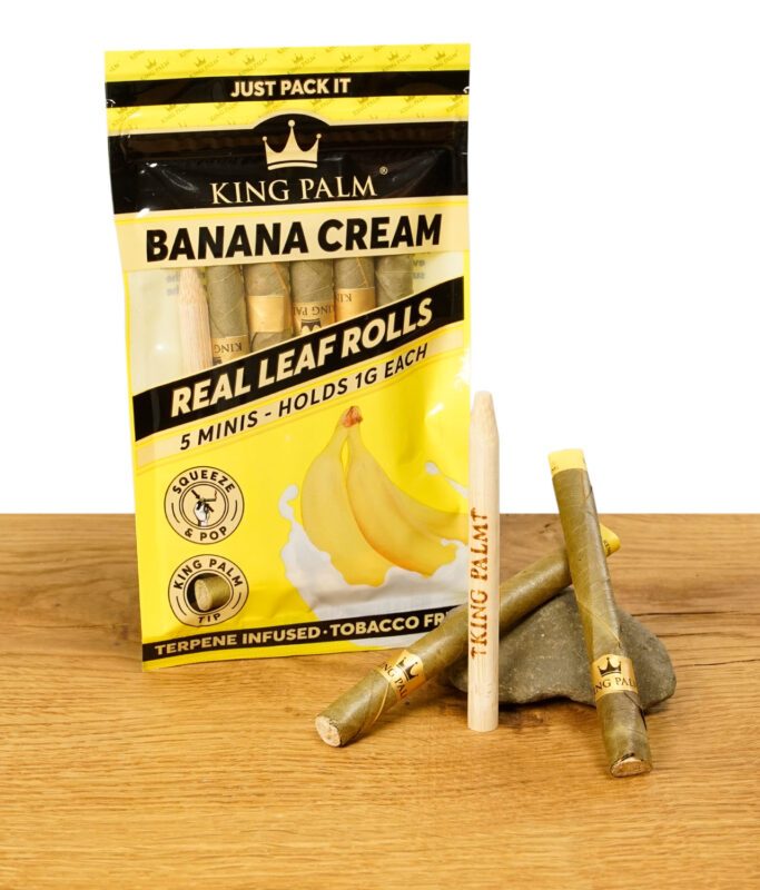 King Palm Banana Cream Packung mit fünf Minis und zwei Blunt Cones auf einem Stein platziert.
