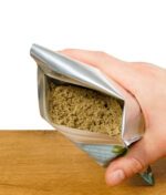 Hand, die die geöffnete Packung des Nature of Spirit Tabakersatzes hält, um den Inhalt der 25g Soft-Mischung zu zeigen.