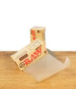 RAW Classic Rolls King Size Zigarettenpapier auf Holzoberfläche, teilweise entrollt.