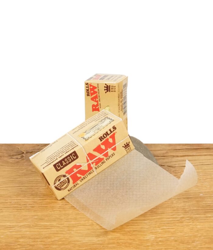 RAW Classic Rolls King Size Zigarettenpapier auf Holzoberfläche, teilweise entrollt.