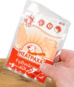 Hand die ein rotes Fußwärmer Pack hält