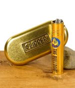 Goldenes Metal Feuerzeug mit The Bulldog Logo neben einer goldenen Clipper Metallbox auf Holzuntergrund.