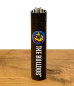 Clipper Metal Feuerzeug in Schwarz mit The Bulldog Logo auf Holzuntergrund.