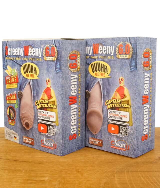 Verpackung des ScreenyWeeny 6.0 Fake-Penis mit Aufschrift „World’s Best Fake Peenis“ und Captain Mittelstrahl, auf einem Holztisch platziert.