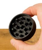 Bio Hanf Grinder von Tyson 2.0 gehalten in einer Hand mit Blockzähnen