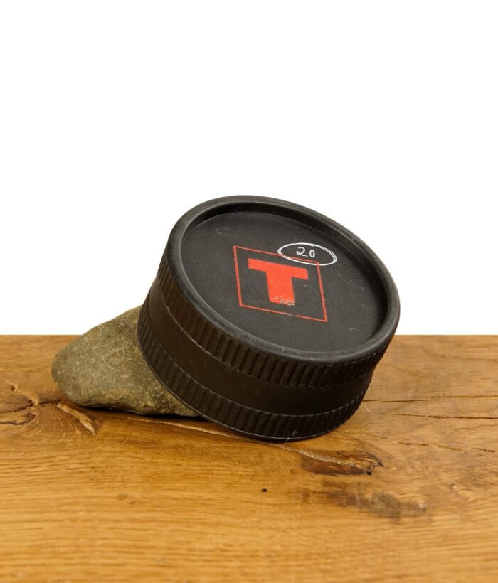 Bio Hanf Grinder von Tyson 2.0 mit rotem T Logo auf einem Stein