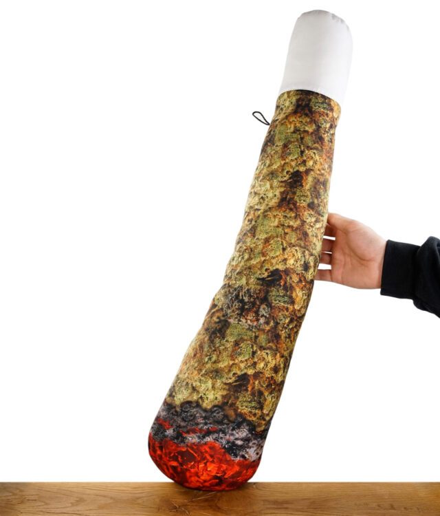 Ganja Pillow Kissen in Jointform auf einem Holztisch vor weißem Hintergrund
