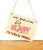 RAW Store Sign Pappschild auf Holzbrett vor weißem Hintergrund