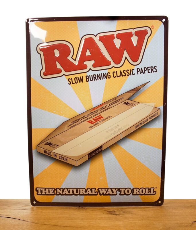 RAW Retro Tin Store Sign auf Metall vor weißem Hintergrund auf Holztisch