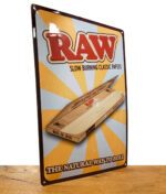 RAW Retro Tin Store Sign auf Metall vor weißem Hintergrund auf Holztisch