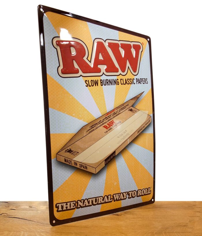 RAW Retro Tin Store Sign auf Metall vor weißem Hintergrund auf Holztisch