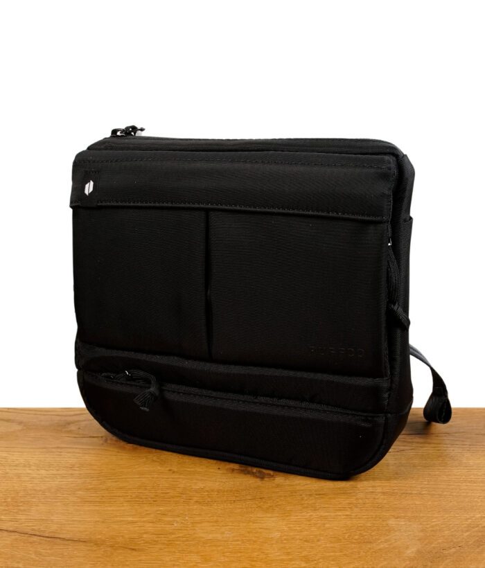 Puffco Proxy Travel Bag in Schwarz auf einem Holzbrett vor weißem Hintergrund