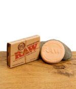 RAW Hydrostone Befeuchtungstein aus Terrakotta mit Verpackung auf Holzuntergrund.