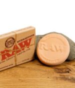 Nahaufnahme des RAW Hydrostone Terrakotta-Befeuchtungsteins und Verpackung auf Holzuntergrund.