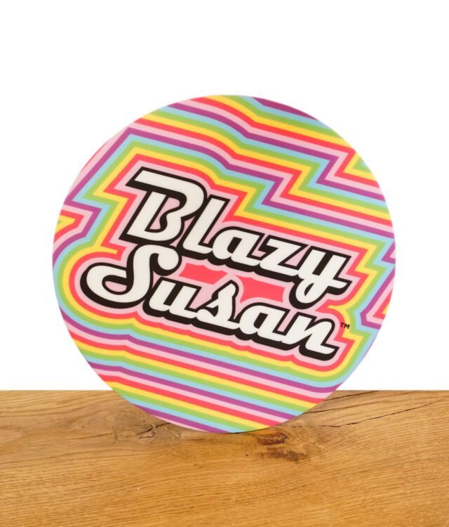 Runde Blazy Susan Drehunterlage mit buntem Regenbogendesign und Logo, auf Holzuntergrund.