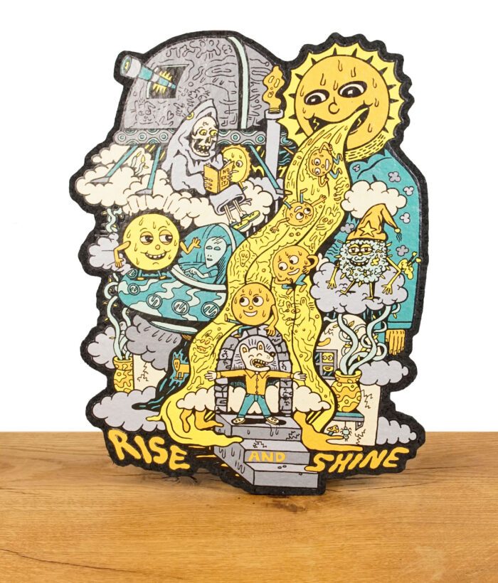 Dab-Mat mit fantasievollem „Rise and Shine“-Design und Sonnenmotiv, aufrecht auf Holzuntergrund.