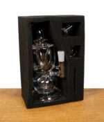 MJ Arsenal Titan Mini Rig sicher verpackt in Schaumstoffeinlage mit Banger und Zubehör.
