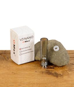 XMax V3 Nano Ersatz-Mundstück mit Verpackung auf einem Holzuntergrund, inklusive Silikonring zur Befestigung.
