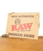RAW Store Sign Pappschild auf einem Holzbrett vor weißem Hintergrund