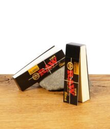 Zwei Packungen RAW Black Classic Tips auf Holzuntergrund, eine liegend und eine stehend, mit natürlichem Design.