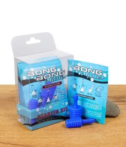 Bong Master Starter Kit mit Reinigungsbeuteln und blauen Silikonstopfen auf Holzuntergrund.