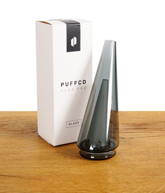 Schwarzer Puffco Peak Pro Glasaufsatz neben der Originalverpackung.