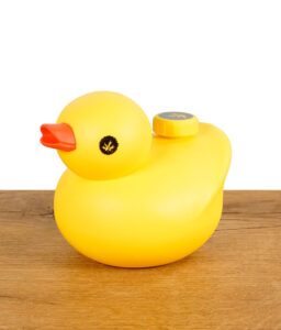 Gelbe PieceMaker KWACK Silikon-Bong in Entenform auf Holztisch.