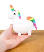 Hand hält die weiße Unikorn Silikon-Bong mit Regenbogen-Mähne und Horn.