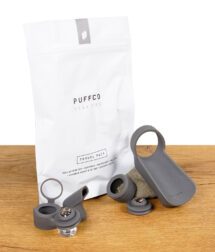 Puffco Peak Pro Travel Pack – Set aus Silikon-Zubehör mit Verpackung auf Holztisch.