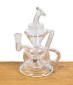 MJ Arsenal Claude Mini Dab Rig ohne Zubehör, klar sichtbar auf Holztisch.