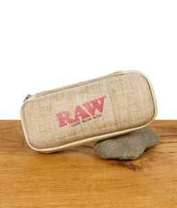 RAW Classic Rolling Papers Aufbewahrungstasche aus Leinen mit rotem RAW-Logo, liegend auf einem Stein.