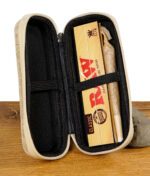 Geöffnete RAW Aufbewahrungstasche mit Gummihalterungen, gefüllt mit RAW Kingsize Slim Papers und einem vorgerollten Joint.