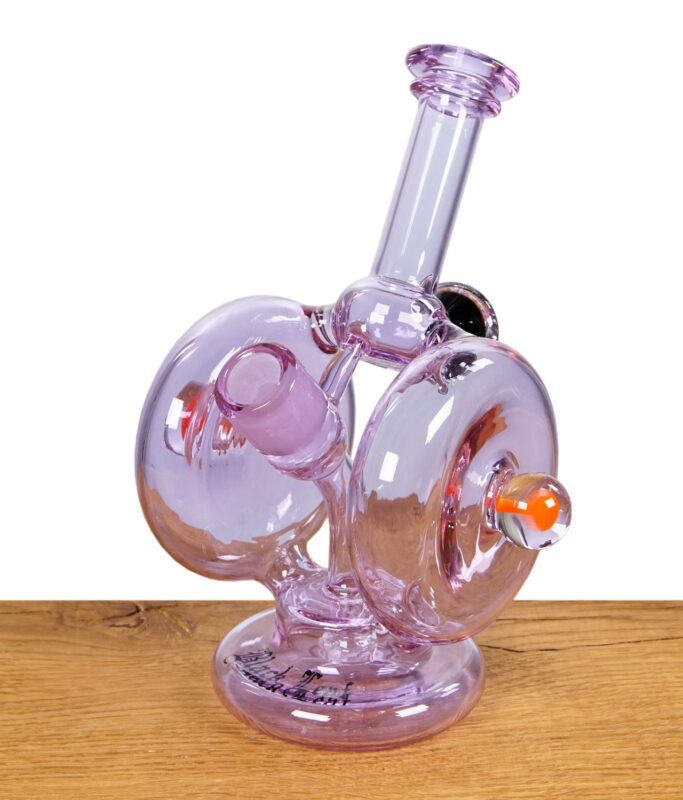 Lila Heady Glass Recycler-Bong mit zwei Kammern und bunten Akzenten auf einem Holztisch.