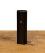 PAX Plus Vaporizer auf Holzuntergrund, minimalistische Ästhetik.