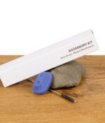 PAX Accessory Kit mit Reinigungsbürste und erhöhtem Mundstück auf Stein platziert.