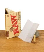 RAW Artesano Organic Hemp Blättchen und Filtertip mit Verpackung im Hintergrund.