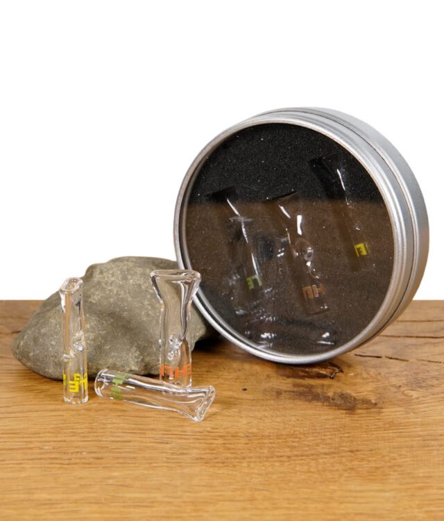 Ein Set aus drei EHLE. Glasfiltertips in einer runden Metallbox mit Sichtfenster, präsentiert auf einer Holzoberfläche.